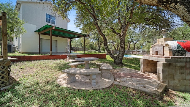 217 Sky View Dr, Adkins, TX 78101 - view of yard featuring an outdoor stone fireplace, a patio area, and cooling unit