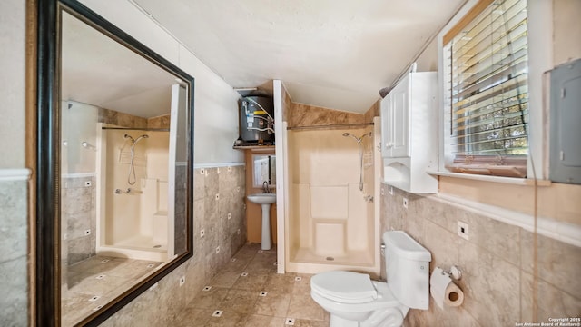 217 Sky View Dr, Adkins, TX 78101 - bathroom with tile walls, a shower stall, tile patterned floors, toilet, and vaulted ceiling