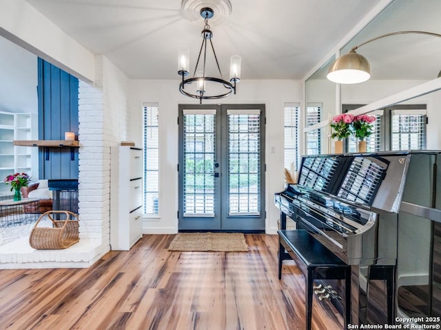 3605 Hidden Unit E1, San Antonio, TX 78217 - foyer featuring a chandelier, french doors, wood finished floors, baseboards, and a brick fireplace