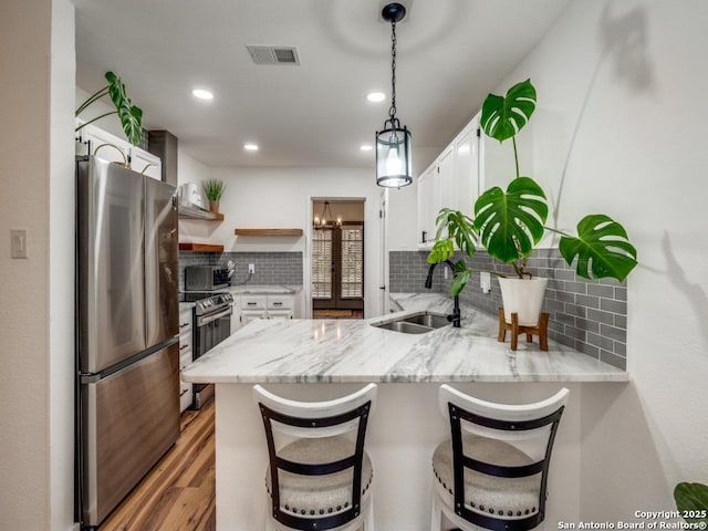 3605 Hidden Unit E1, San Antonio, TX 78217 - kitchen featuring a sink, appliances with stainless steel finishes, a peninsula, open shelves, and white cabinetry