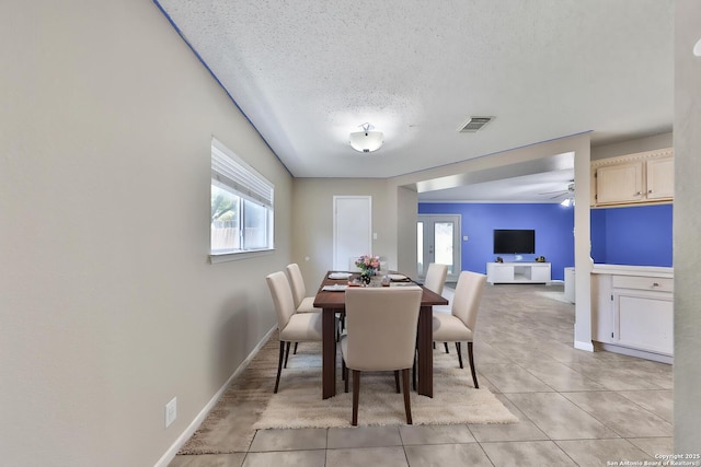 807 S Ellison Dr, San Antonio, TX 78245 - dining area with healthy amount of natural light, a textured ceiling, light tile patterned floors, a ceiling fan, and baseboards