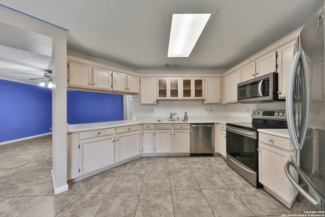 807 S Ellison Dr, San Antonio, TX 78245 - kitchen with appliances with stainless steel finishes, a sink, a textured ceiling, light countertops, and light tile patterned floors