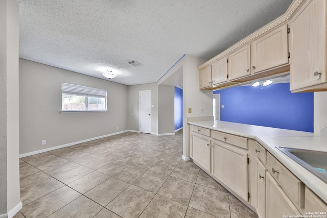 807 S Ellison Dr, San Antonio, TX 78245 - kitchen featuring light tile patterned floors, light countertops, a textured ceiling, baseboards, and a sink
