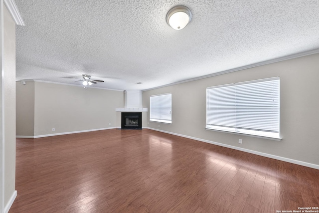 807 S Ellison Dr, San Antonio, TX 78245 - unfurnished living room featuring ceiling fan, a textured ceiling, baseboards, dark wood-style flooring, and a fireplace