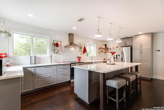 9811 Rebel Queen, San Antonio, TX 78255 - kitchen featuring stainless steel appliances, wall chimney exhaust hood, gray cabinetry, decorative backsplash, and recessed lighting