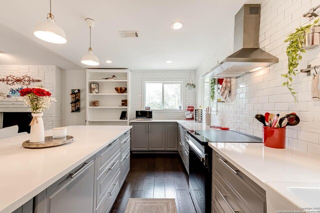 9811 Rebel Queen, San Antonio, TX 78255 - kitchen with stainless steel appliances, wall chimney exhaust hood, gray cabinetry, decorative backsplash, and dark wood-style floors