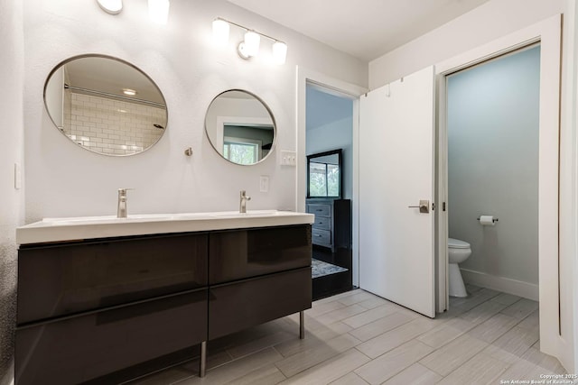 9811 Rebel Queen, San Antonio, TX 78255 - full bathroom with toilet, double vanity, wood tiled floors, and baseboards