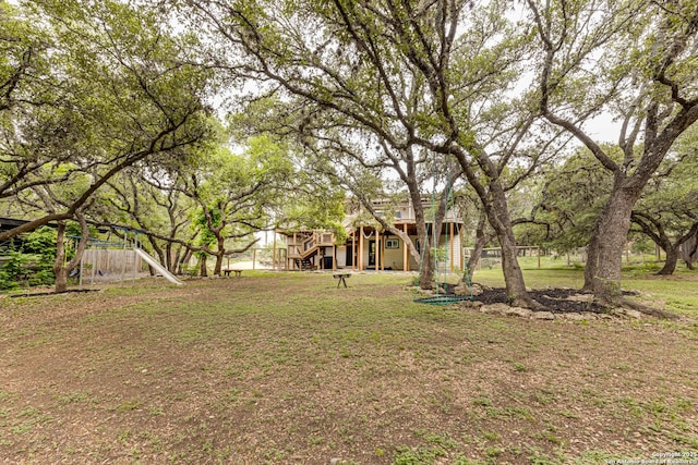 9811 Rebel Queen, San Antonio, TX 78255 - view of green lawn featuring stairway, a wooden deck, and a playground