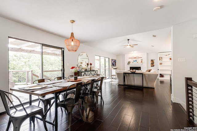 9811 Rebel Queen, San Antonio, TX 78255 - dining area with a fireplace, dark wood-style flooring, ceiling fan, lofted ceiling, and baseboards