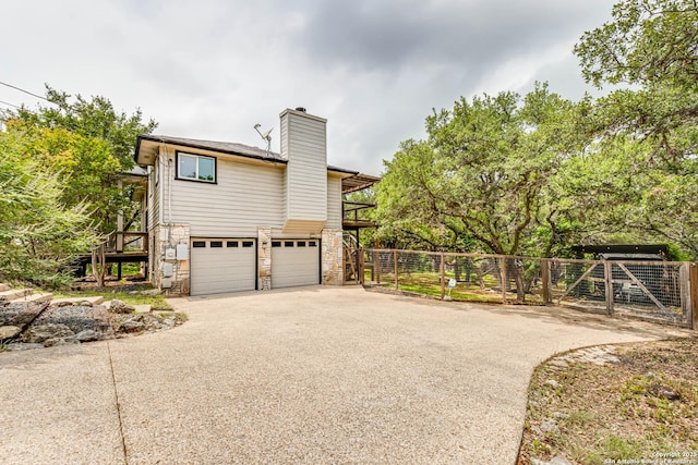 9811 Rebel Queen, San Antonio, TX 78255 - view of property exterior featuring stone siding, driveway, fence, a chimney, and a garage