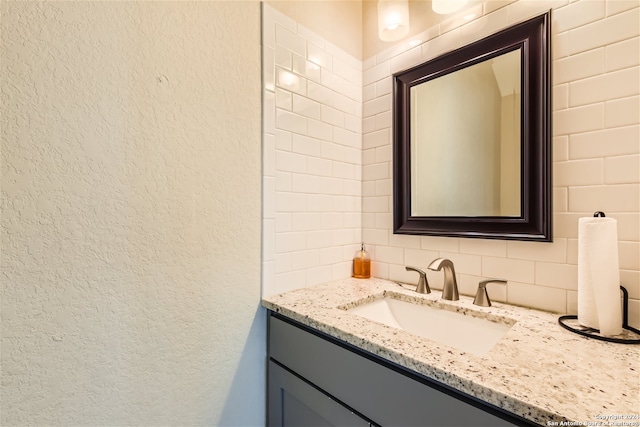 1130 Wyoming St Unit B, San Antonio, TX 78203 - bathroom featuring vanity, decorative backsplash, and a textured wall