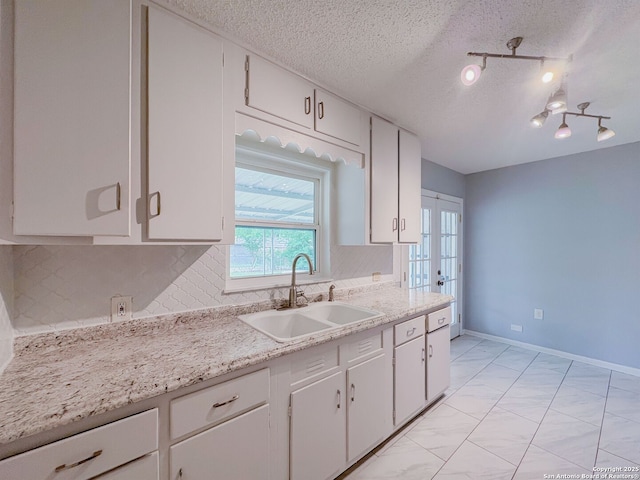 155 Eland, San Antonio, TX 78213 - kitchen with a sink, light countertops, french doors, tasteful backsplash, and a textured ceiling