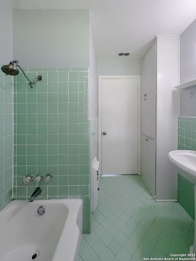 155 Eland, San Antonio, TX 78213 - full bath with tile patterned flooring, tub / shower combination, tile walls, and a textured ceiling