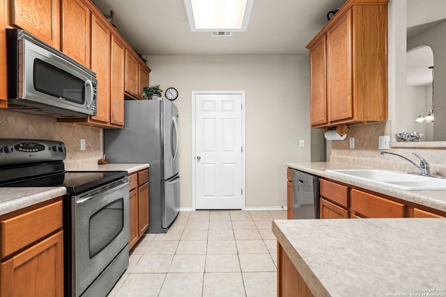 3136 San Miguel, New Braunfels, TX 78132 - kitchen with appliances with stainless steel finishes, a sink, light tile patterned flooring, and backsplash