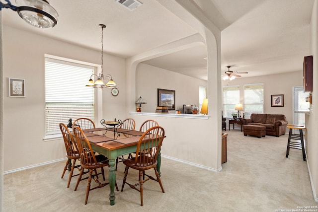 3136 San Miguel, New Braunfels, TX 78132 - dining room featuring light carpet, a chandelier, baseboards, ceiling fan, and arched walkways