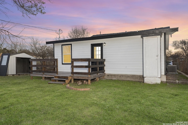 1527 W French Pl, San Antonio, TX 78201 - back of property with a wooden deck, a lawn, an outbuilding, a storage shed, and central AC unit