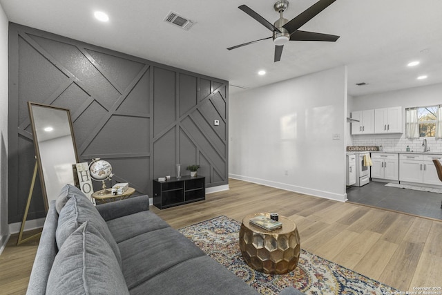 1527 W French Pl, San Antonio, TX 78201 - living area with a ceiling fan, wood finished floors, a decorative wall, baseboards, and recessed lighting