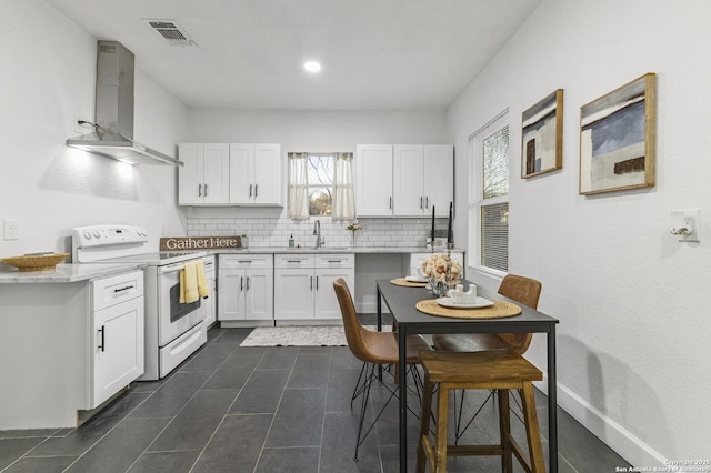 1527 W French Pl, San Antonio, TX 78201 - kitchen with electric range, wall chimney exhaust hood, tasteful backsplash, white cabinetry, and recessed lighting
