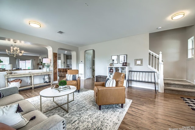 1227 Sun Spg, San Antonio, TX 78245 - living room featuring arched walkways, wood finished floors, a chandelier, and stairway