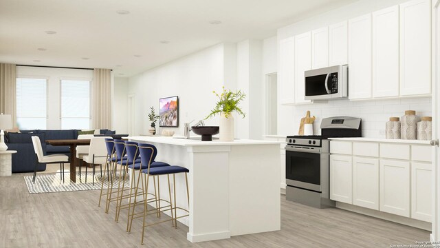 5223 Whirling Pl, San Antonio, TX 78253 - kitchen featuring appliances with stainless steel finishes, light wood finished floors, a breakfast bar area, white cabinetry, and tasteful backsplash