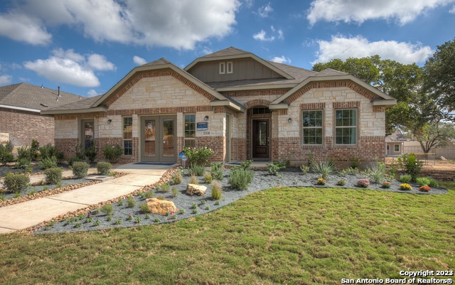 8907 Turkey Crk, Seguin, TX 78155 - view of front of home with french doors, a front lawn, stone siding, and brick siding