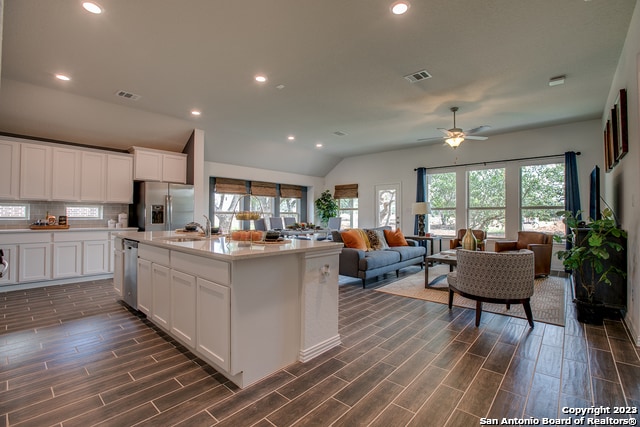 8907 Turkey Crk, Seguin, TX 78155 - kitchen with stainless steel appliances, dark wood-type flooring, backsplash, white cabinets, and a sink