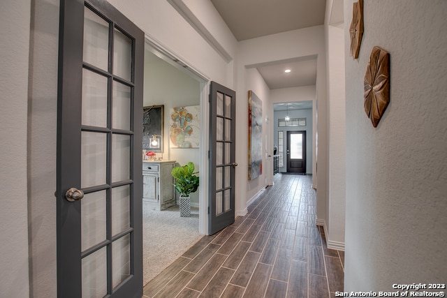 8907 Turkey Crk, Seguin, TX 78155 - hall featuring dark wood-style floors, baseboards, french doors, a textured wall, and recessed lighting