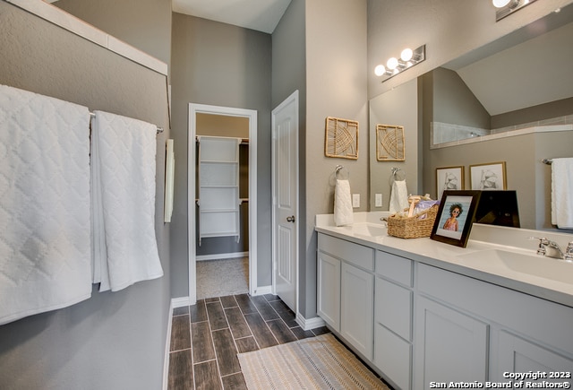 8907 Turkey Crk, Seguin, TX 78155 - full bath featuring double vanity, wood finish floors, lofted ceiling, and a walk in closet