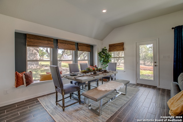 8907 Turkey Crk, Seguin, TX 78155 - dining area featuring wood tiled floors, vaulted ceiling, baseboards, and recessed lighting