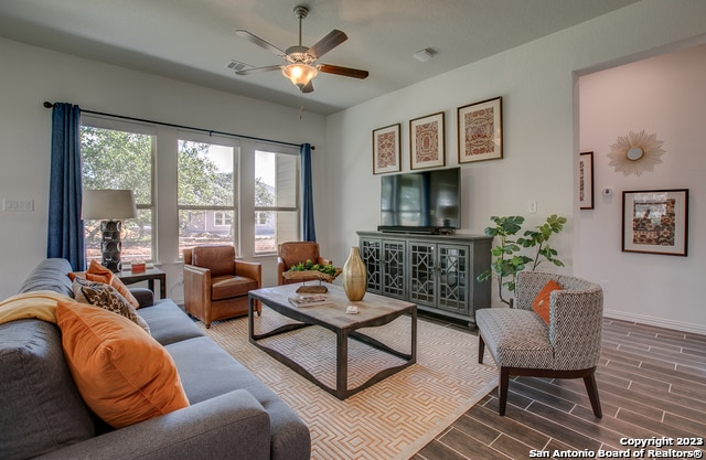 8907 Turkey Crk, Seguin, TX 78155 - living area featuring wood finished floors, ceiling fan, and baseboards