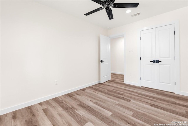 unfurnished bedroom with light wood finished floors, baseboards, a ceiling fan, and a closet