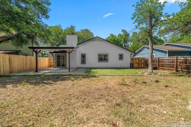 rear view of house with a patio and a chimney