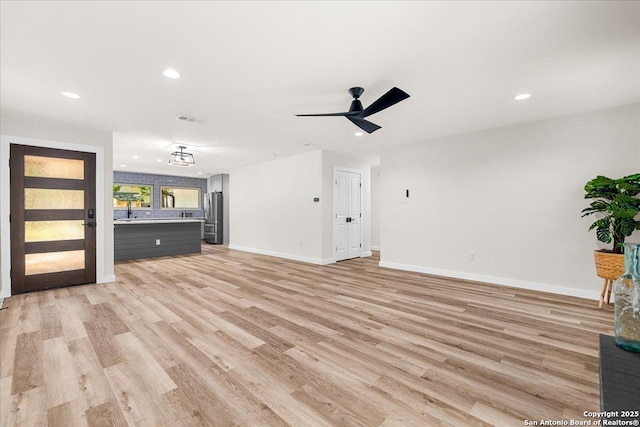 unfurnished living room with light wood-style flooring, recessed lighting, baseboards, and ceiling fan
