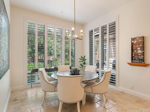 7 Naples Ct, San Antonio, TX 78257 - dining space with stone tile flooring, baseboards, and a chandelier