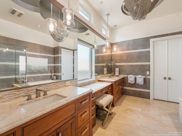 7 Naples Ct, San Antonio, TX 78257 - bathroom with vanity, a garden tub, a chandelier, tile patterned flooring, and tile walls