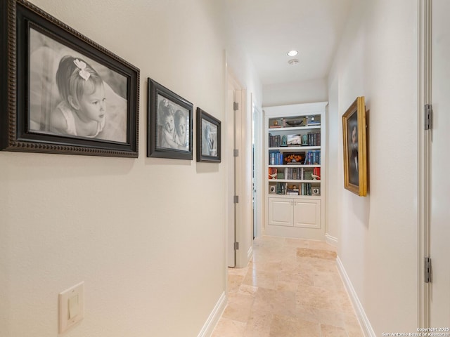 7 Naples Ct, San Antonio, TX 78257 - hall with baseboards, stone tile flooring, built in shelves, and recessed lighting