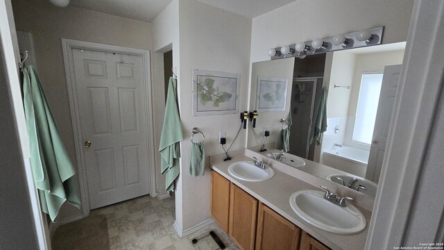 9406 Vallecito Pass, San Antonio, TX 78250 - full bathroom with a stall shower, a garden tub, double vanity, and baseboards