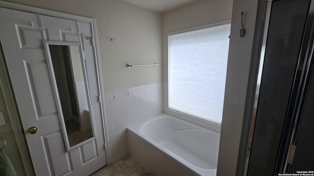 9406 Vallecito Pass, San Antonio, TX 78250 - full bathroom with a bath, tile walls, and a wainscoted wall