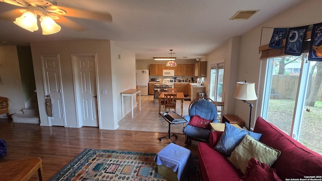 9406 Vallecito Pass, San Antonio, TX 78250 - living area with light wood-style flooring, a ceiling fan, and stairway