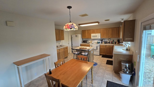 9406 Vallecito Pass, San Antonio, TX 78250 - kitchen with white appliances, light tile patterned flooring, light countertops, pendant lighting, and brown cabinetry