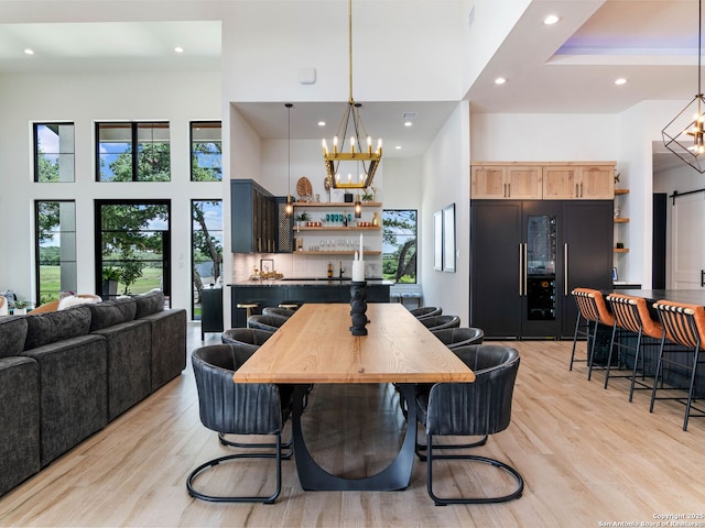 756 Annabelle Ave, Bulverde, TX 78163 - dining room featuring a chandelier, bar, light wood-style floors, recessed lighting, and a towering ceiling