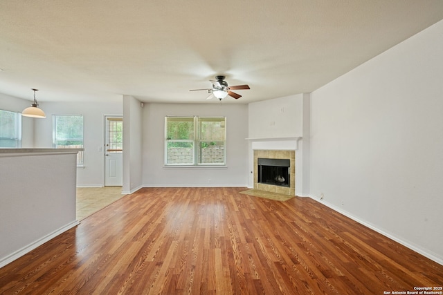 15603 Hastings Park, Selma, TX 78154 - unfurnished living room featuring ceiling fan, light wood-style floors, a fireplace, and baseboards