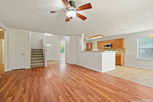 15603 Hastings Park, Selma, TX 78154 - unfurnished living room featuring light wood-type flooring, plenty of natural light, stairs, and ceiling fan