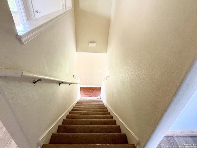 2211 Mission Verde, San Antonio, TX 78223 - stairs featuring baseboards, wood finished floors, and a textured wall