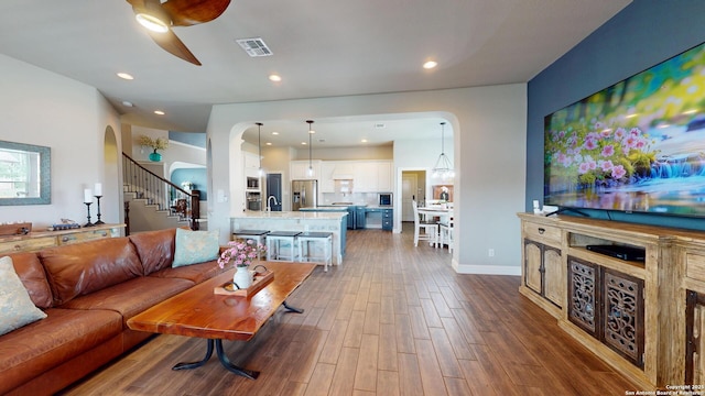 2542 Varrelmann, New Braunfels, TX 78132 - living area with arched walkways, dark wood-style floors, a ceiling fan, stairs, and recessed lighting