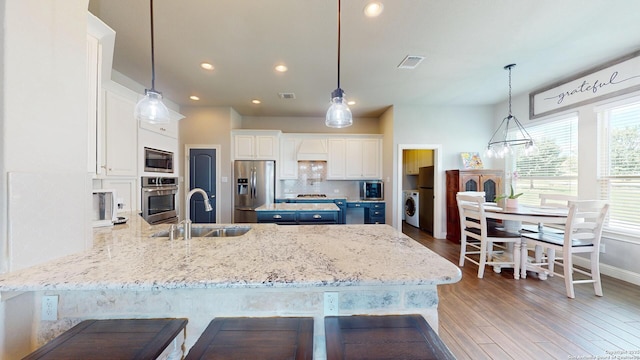 2542 Varrelmann, New Braunfels, TX 78132 - kitchen with a sink, stainless steel appliances, a peninsula, light wood-style floors, and white cabinetry