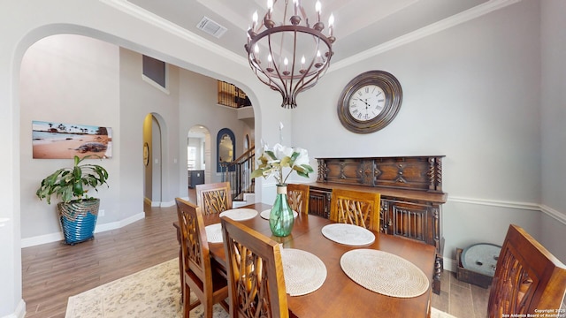 2542 Varrelmann, New Braunfels, TX 78132 - dining area featuring arched walkways, a chandelier, wood finished floors, baseboards, and crown molding