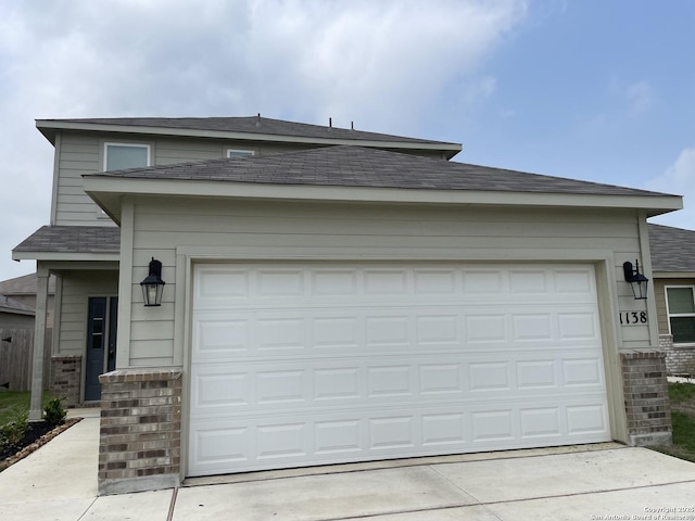 1138 Gracie Way, New Braunfels, TX 78130 - view of front facade featuring driveway, a shingled roof, brick siding, and an attached garage