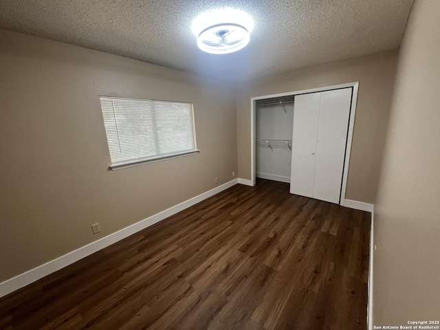 15558 Knollmeadow, San Antonio, TX 78247 - unfurnished bedroom featuring dark wood-style floors, baseboards, a textured ceiling, and a closet
