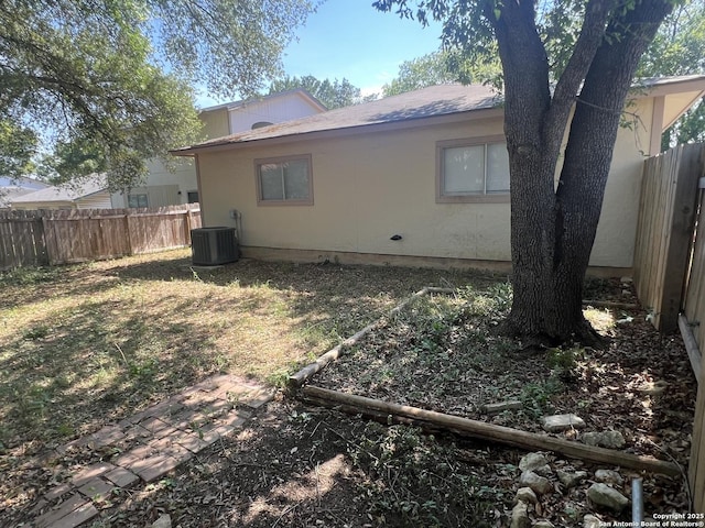 15558 Knollmeadow, San Antonio, TX 78247 - view of property exterior featuring central AC, a fenced backyard, and roof with shingles